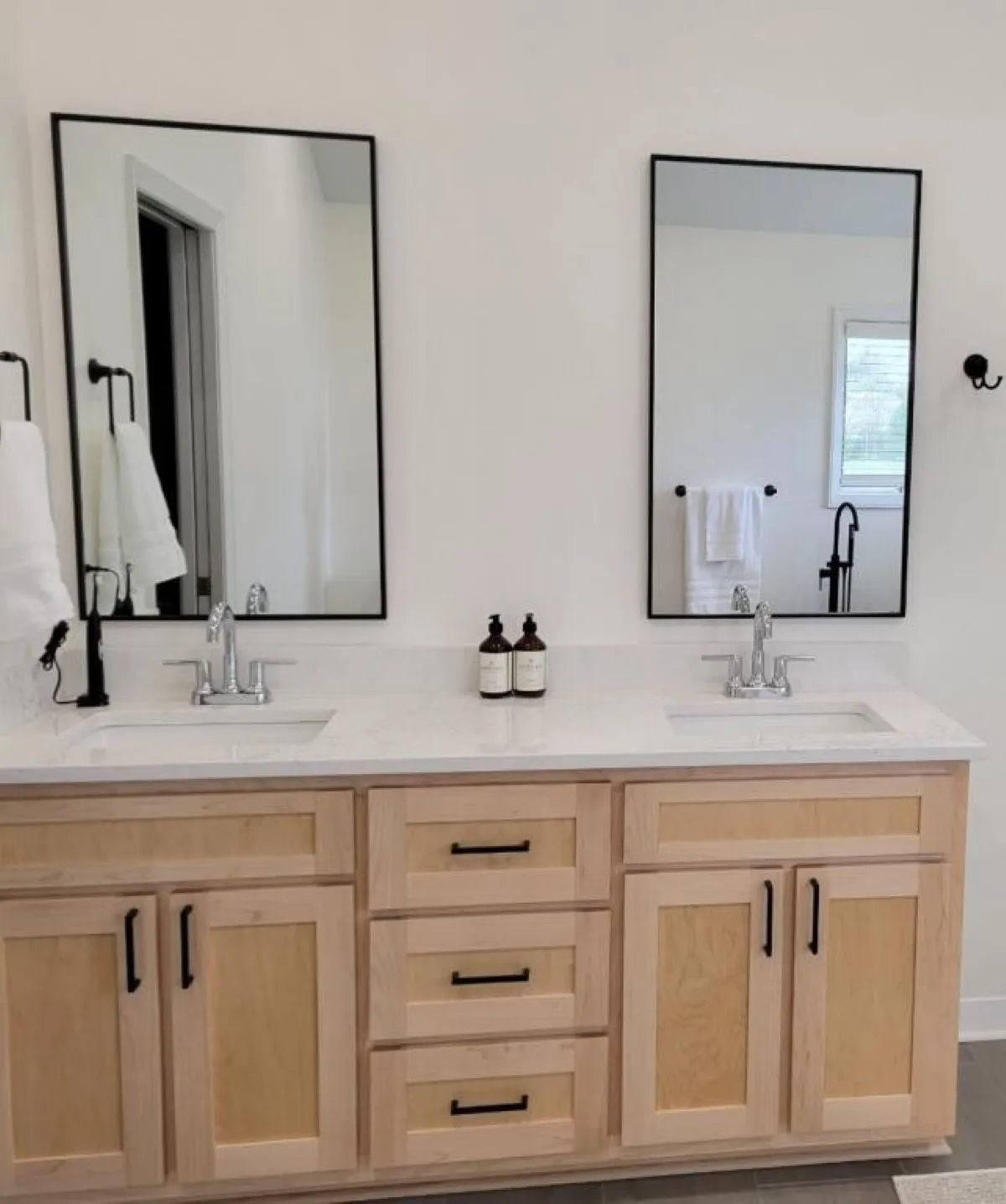 Custom vanity with double sinks, mirrors, and black hardware