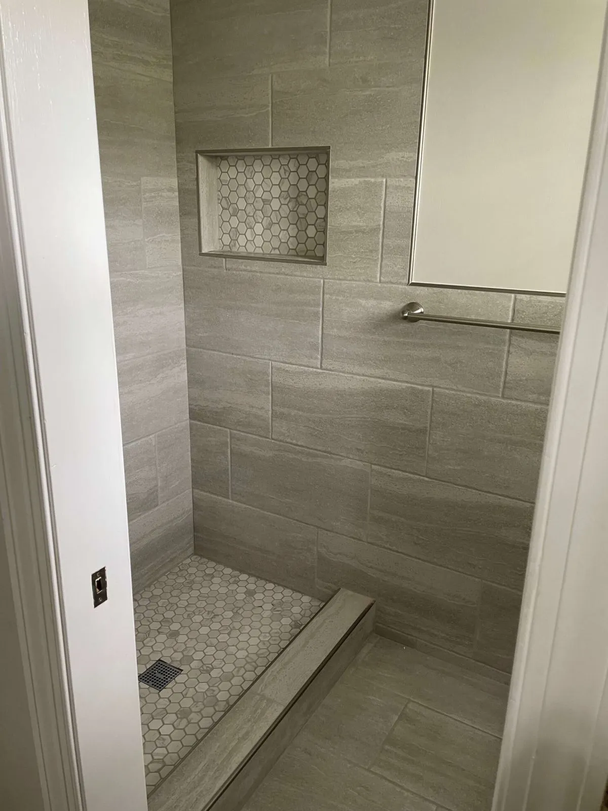 Modern gray tile walk-in shower with built-in niche