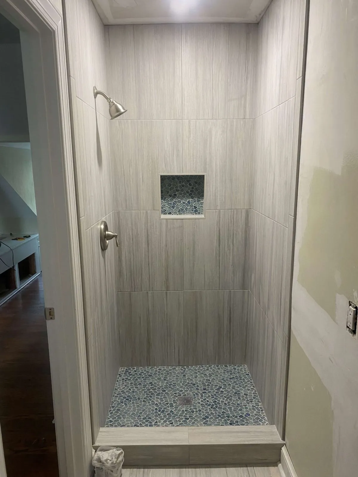 Frameless shower with vertical tile and square shampoo niche