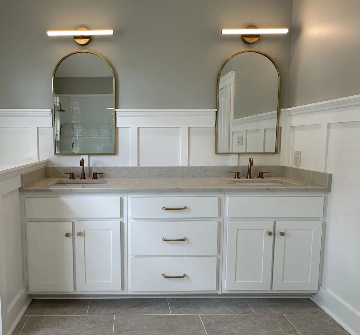 Custom bathroom vanity with double sinks, quartz top, and arched mirrors in Virginia Beach remodel