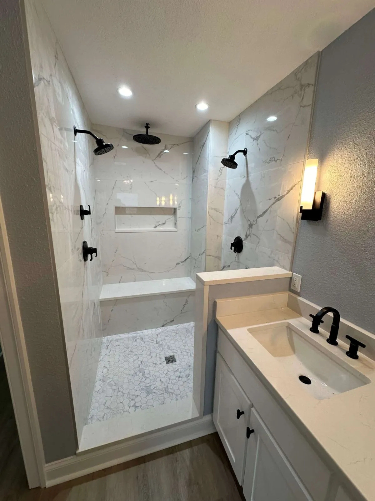 Bathroom lighting upgrade with pendants, wall sconces, and modern tile accents
