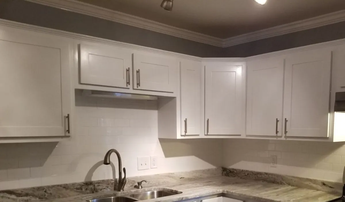 White shaker kitchen cabinets with full-overlay doors, deep drawers, and stainless hardware