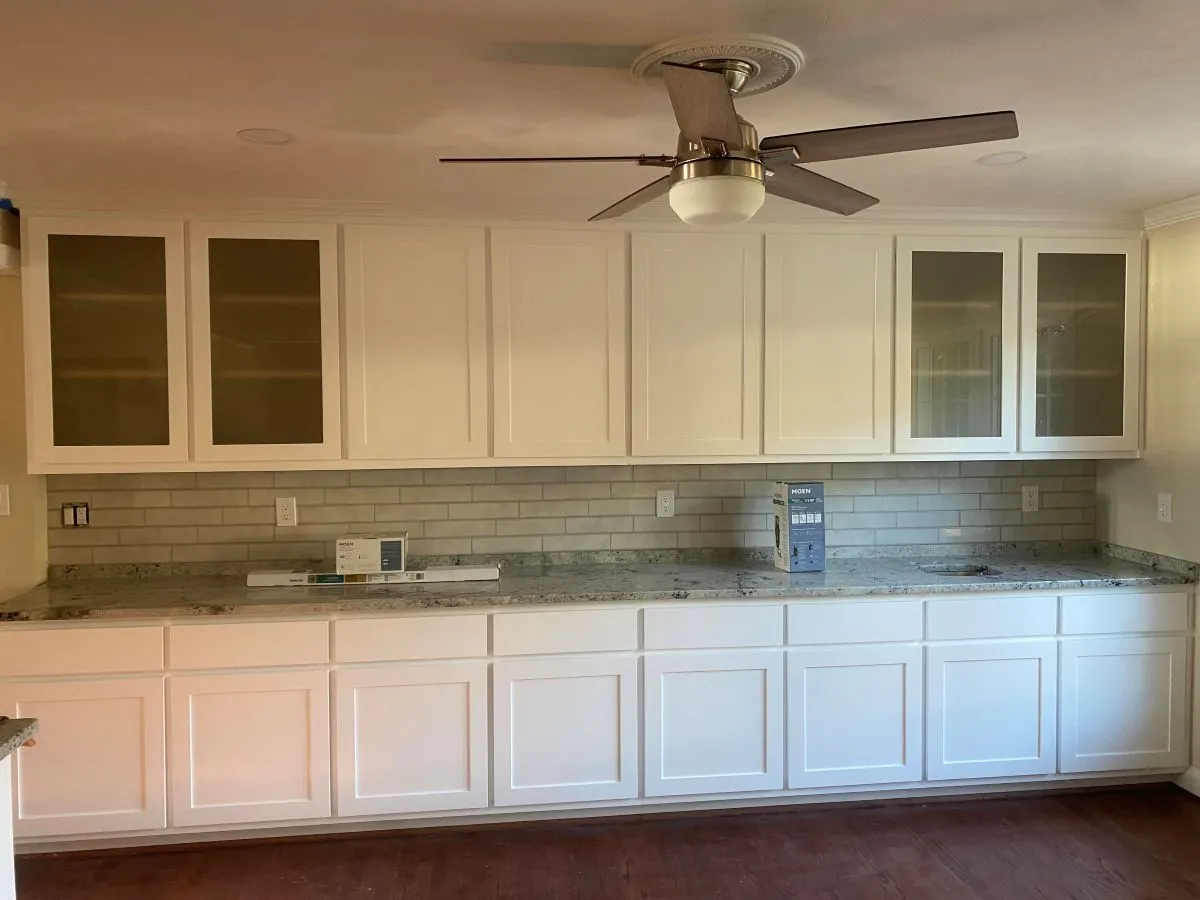 Built-in wall unit with closed lower cabinets and open upper shelves for home storage