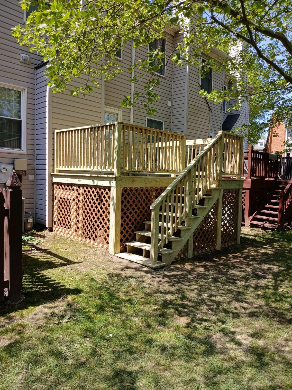 New pressure-treated deck with stairs and lattice skirting on a residential home