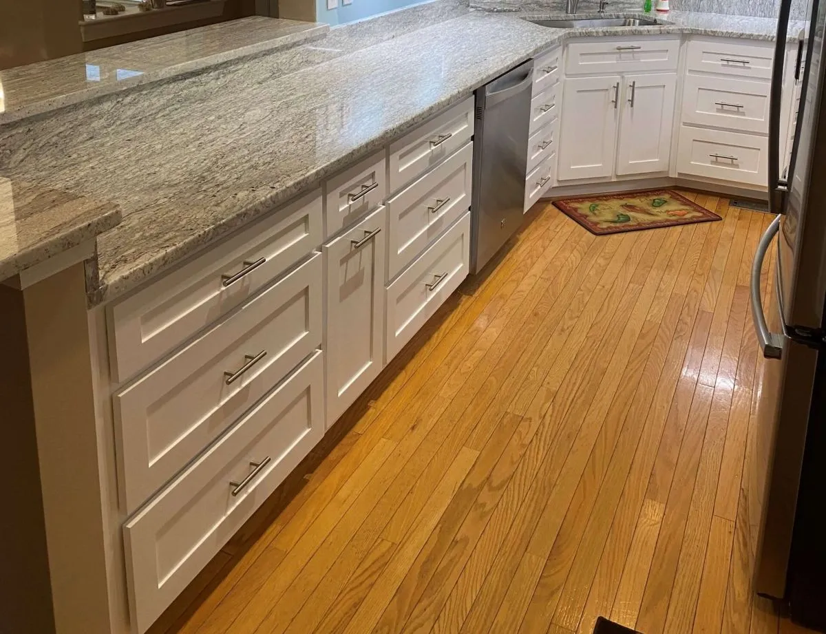Refinished hardwood flooring in a transitional kitchen with granite countertops