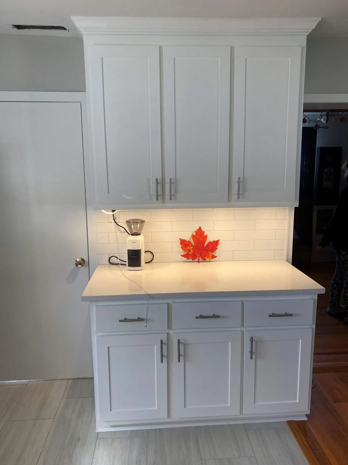 Cabinet built-in with undercabinet lighting and tile backsplash