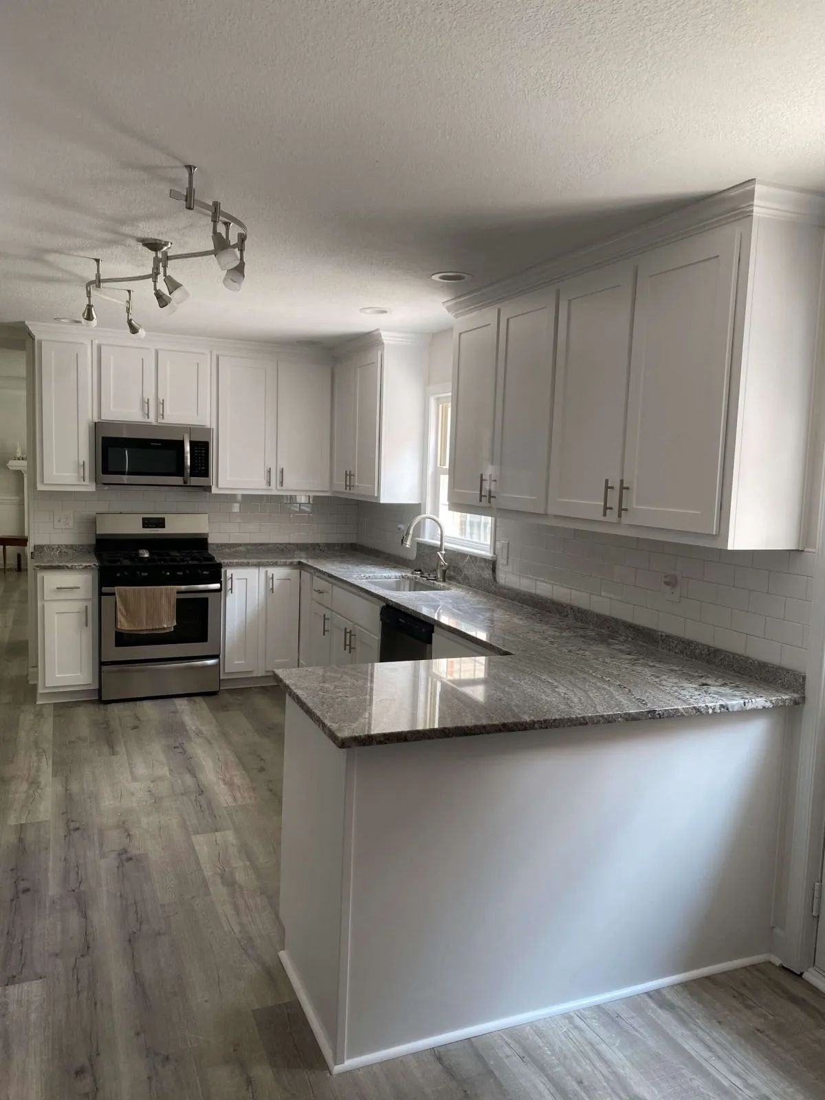 L-shaped kitchen remodel with light floors and granite surfaces