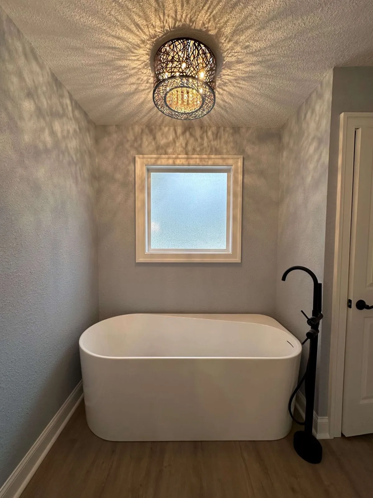 Bathroom remodel with freestanding tub and textured wall finish