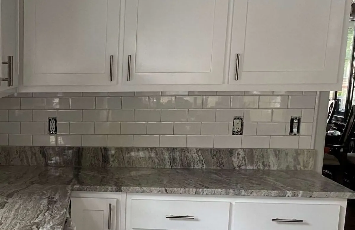 Tile backsplash installation with subway pattern and granite counters