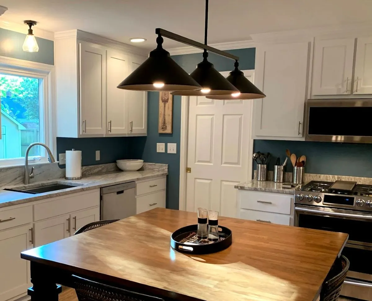 Kitchen lighting upgrade with recessed cans and modern pendant fixtures over island