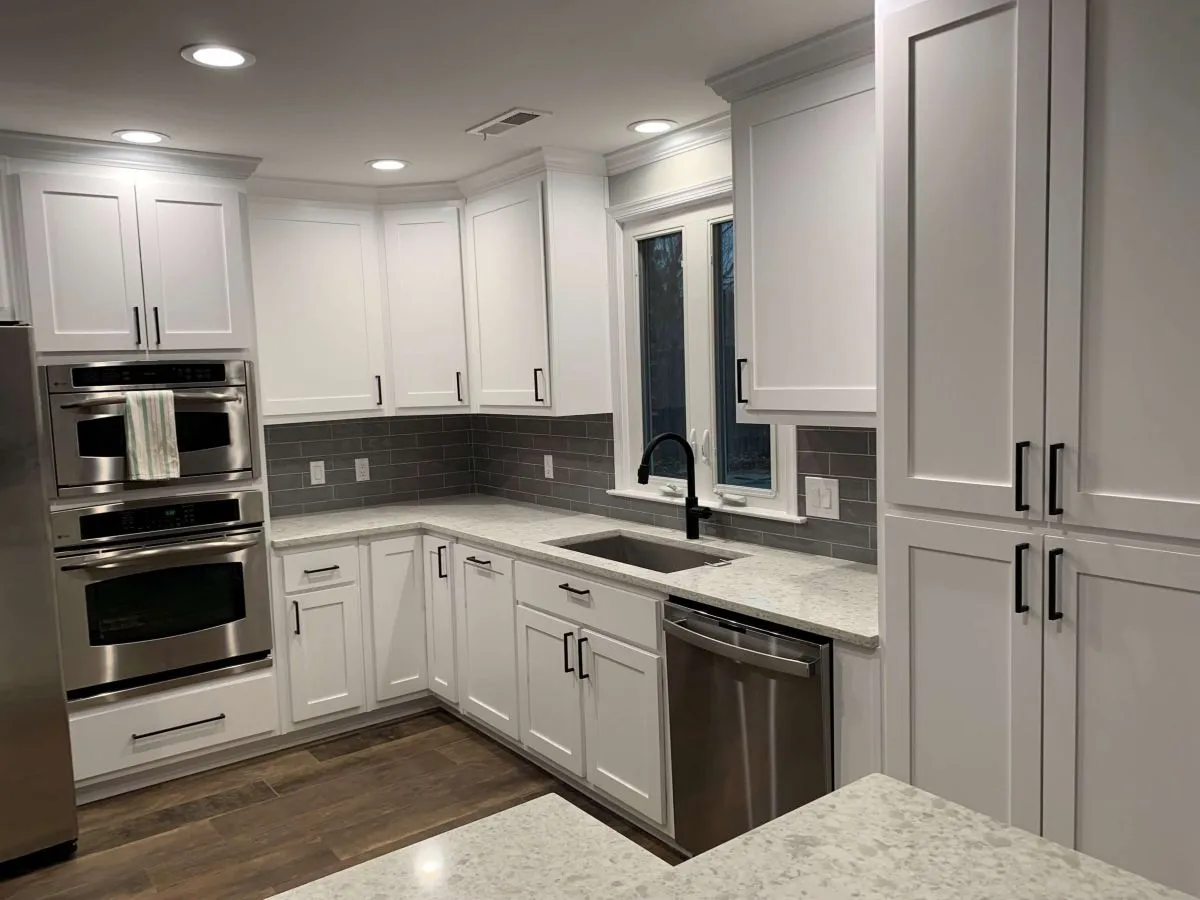 Custom kitchen remodel with white cabinets and dark granite countertops