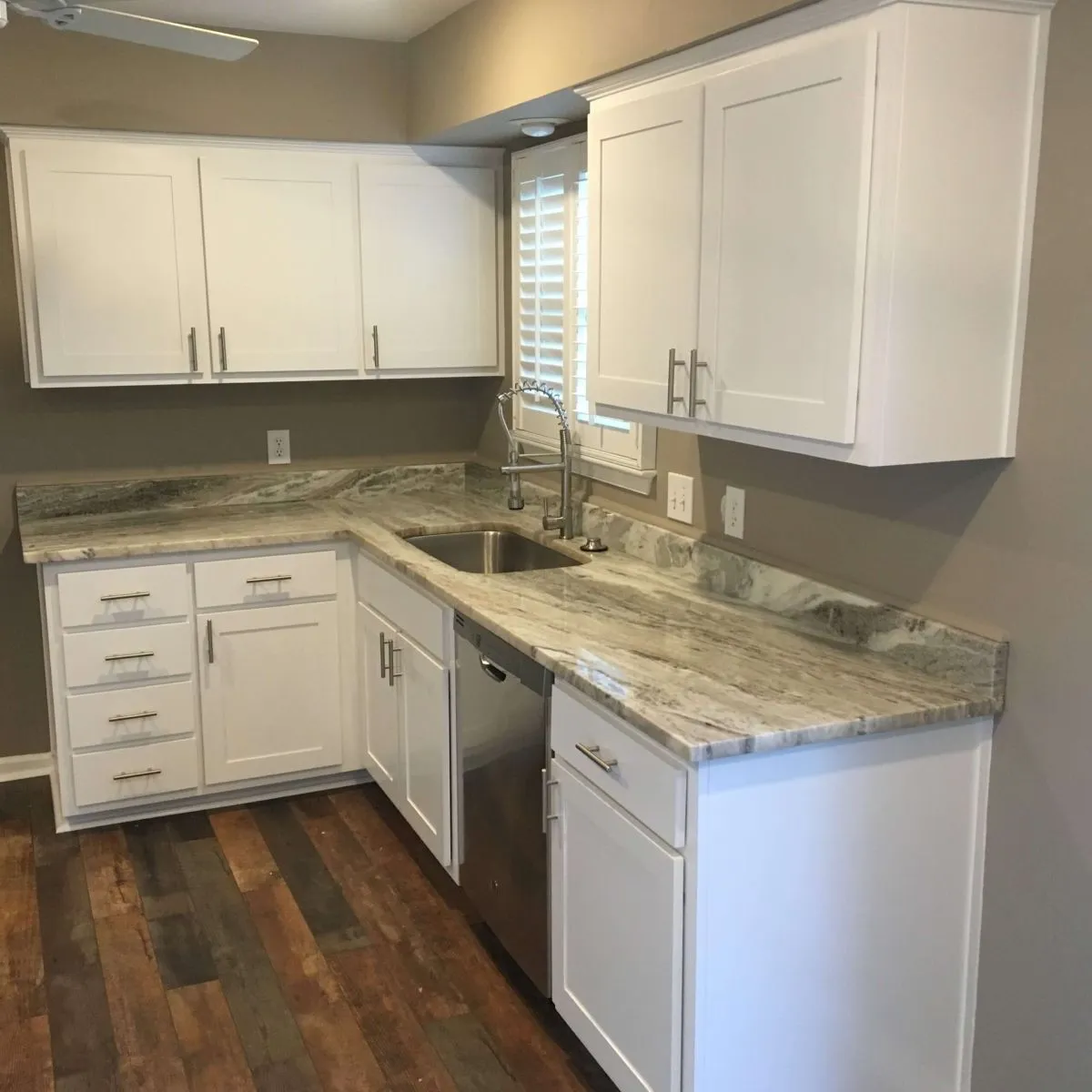 U-shaped kitchen with speckled counters and shaker cabinetry