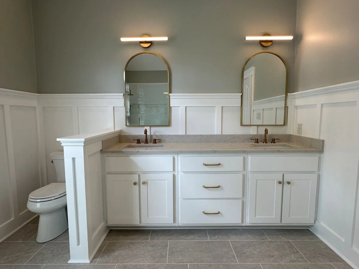 After: upgraded white double vanity with quartz counter and dual mirrors