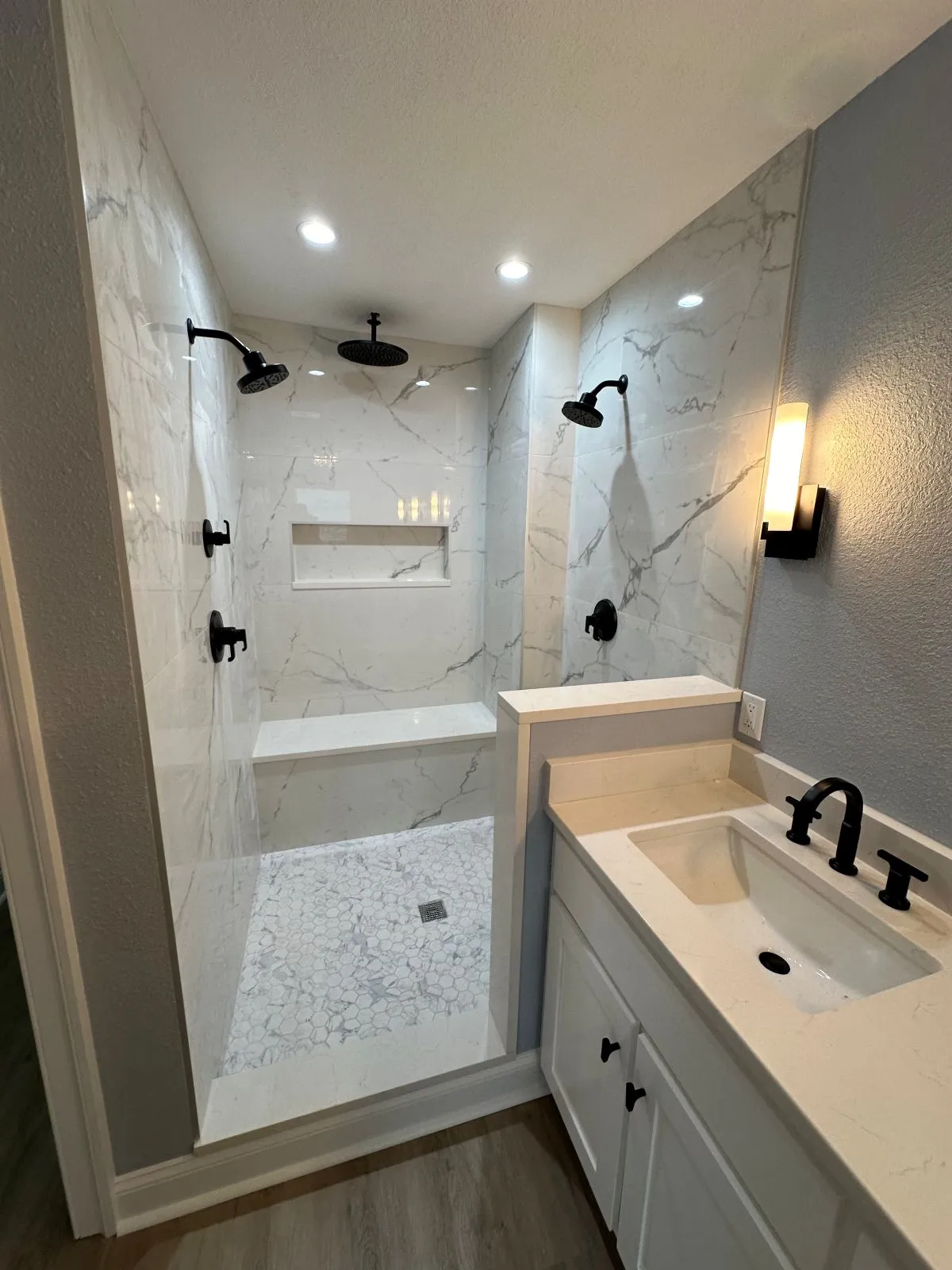 Fully rebuilt bathroom with walk-in tile shower, new vanity, and black matte fixtures